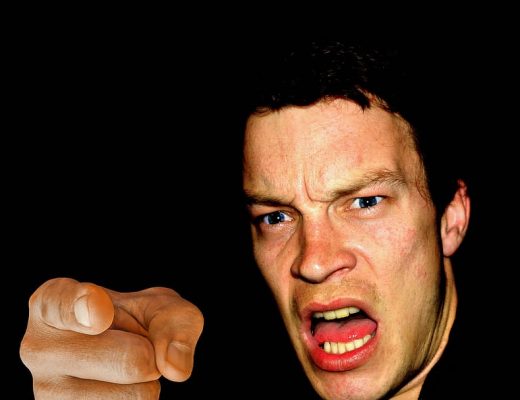 a very furious man pointing